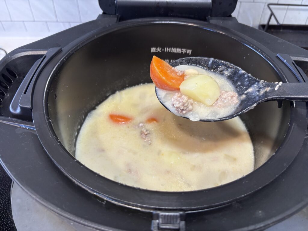 ホットクックのクリームシチューに牛乳を追加しているところ