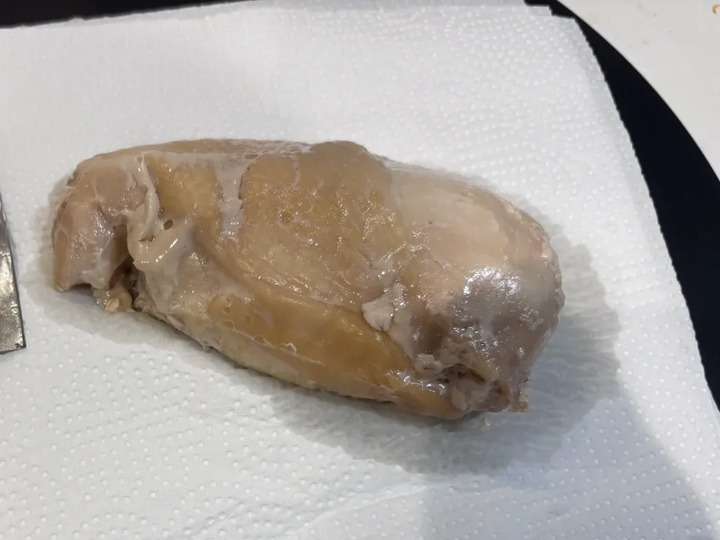 調理後の鶏むね肉1個をキッチンペーパーの上に取り出した様子とナイフ