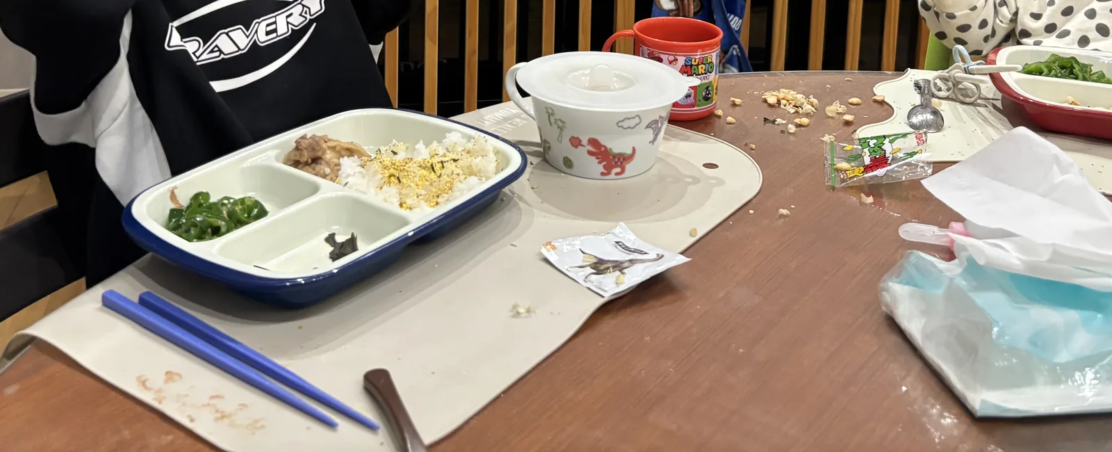食べかけの給食トレーとパンくずが散らかった食卓