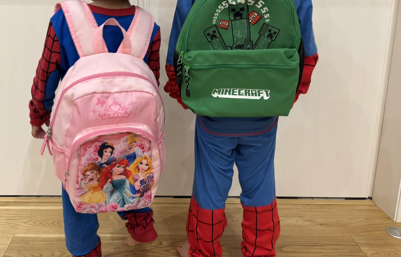 小さなリュックを背負った子ども2人の後ろ姿