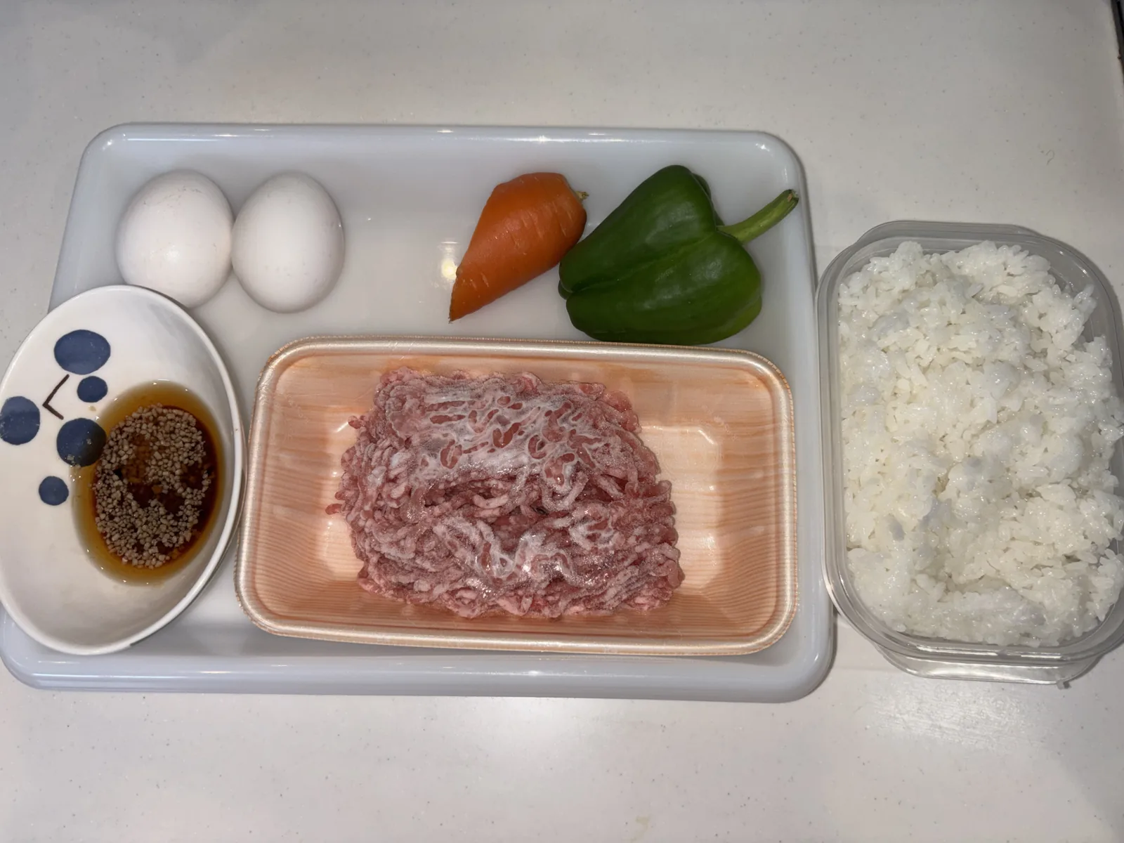 ホットクックチャーハンの材料(卵・にんじん・ピーマン・豚ひき肉・ごはん・調味料)