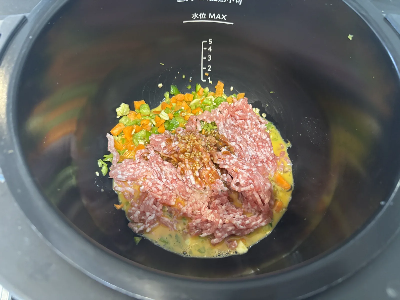 ホットクックの内鍋に溶き卵・野菜・豚ひき肉・調味料を入れたところ