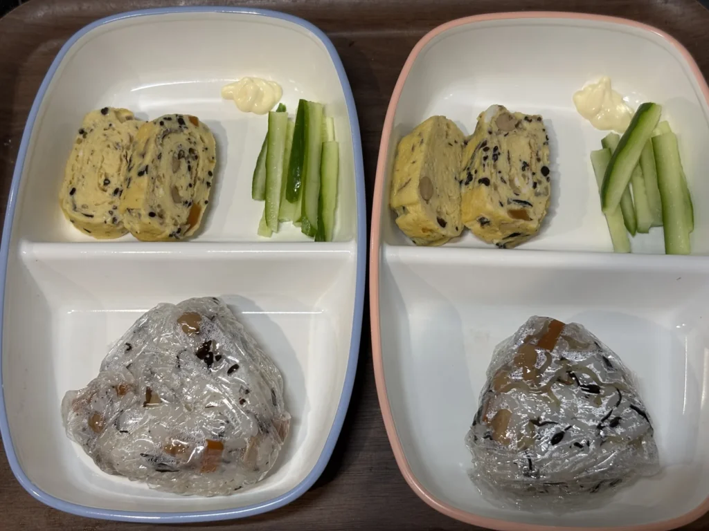 子ども2人ぶんの朝ごはん。器の手前がひじきを混ぜ込んだおにぎり、奥がひじき入りの卵焼きときゅうりのスティック
