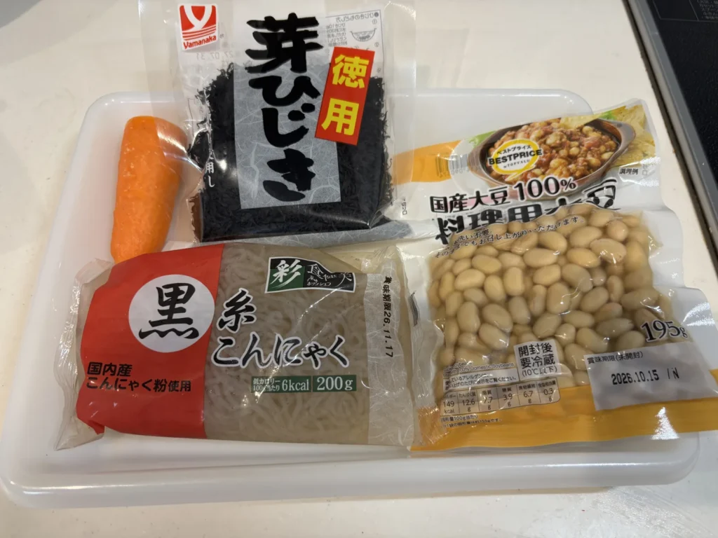 トレーに並べた材料。芽ひじき(乾燥・徳用)、糸こんにゃく200g、国産大豆水煮、にんじん