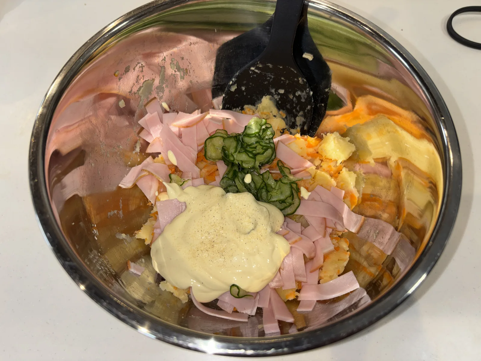 ステンレスボウルに移したポテトサラダにマヨネーズ・ハム・きゅうりを加えたところ