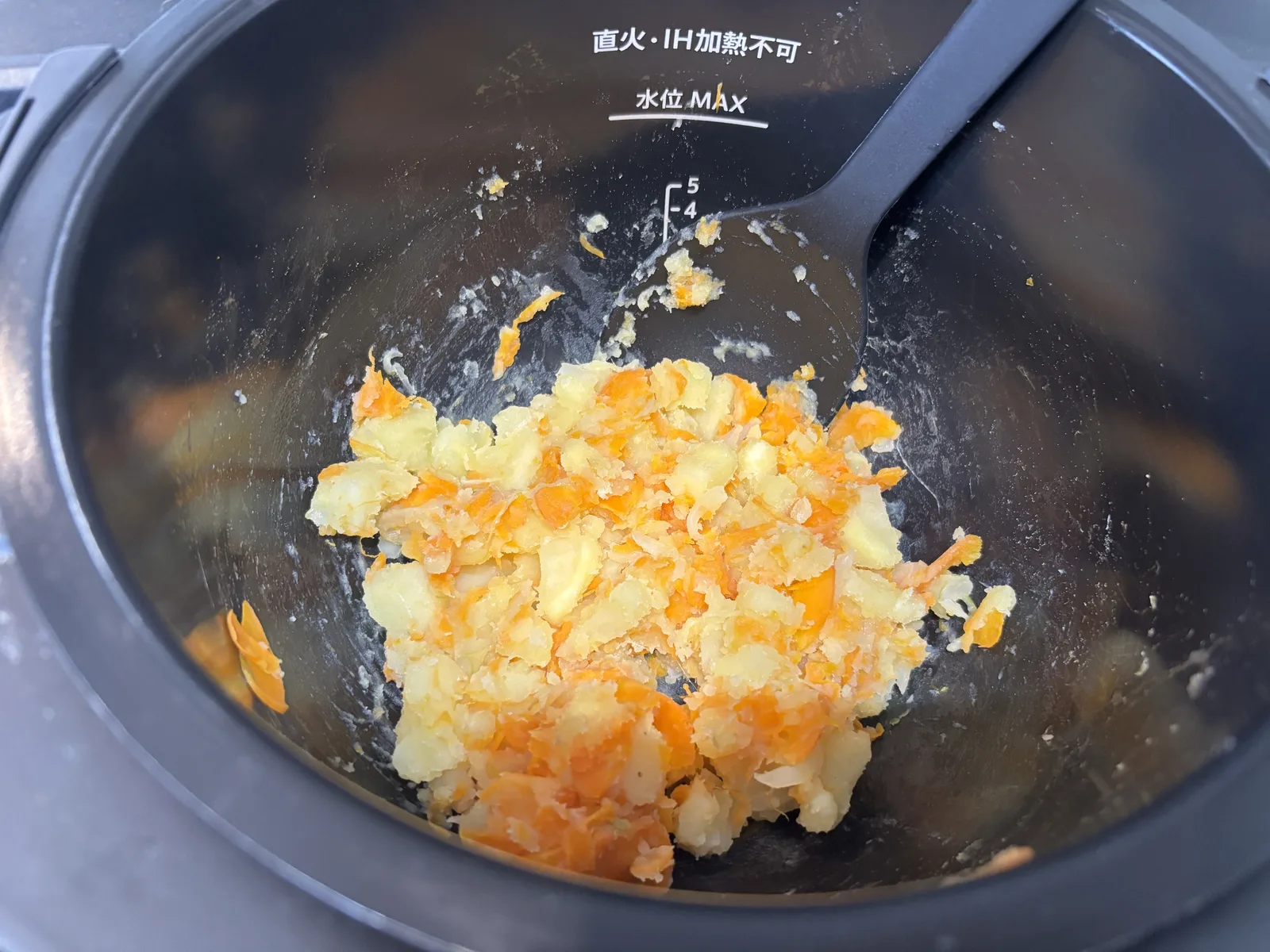 加熱後の内鍋。じゃがいもとにんじんがつぶれて黄色とオレンジが混ざっている
