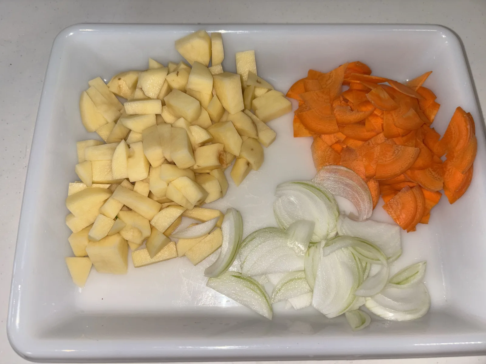 トレーにまとめた切り終えた野菜3種。角切りのじゃがいも、薄切りの玉ねぎ、薄切りのにんじん
