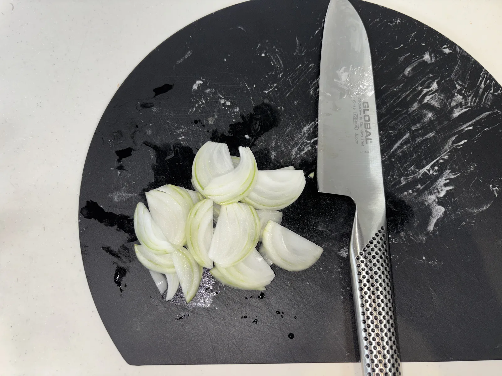玉ねぎを包丁で薄切りにしているところ
