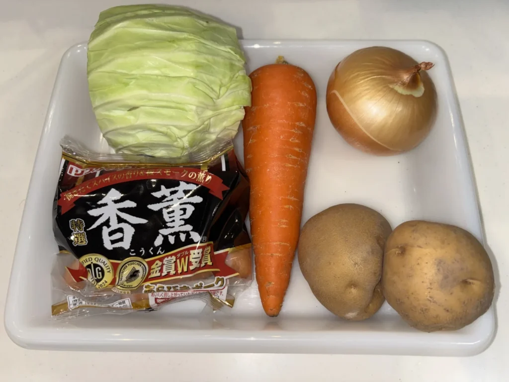 トレーに並べた材料一式。キャベツ・にんじん・玉ねぎ・じゃがいも・あらびきポークウインナー
