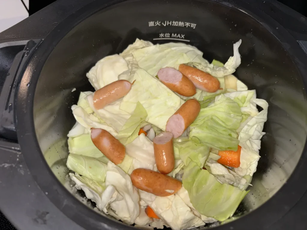 内鍋に材料を入れた状態。キャベツとウインナーが見えている